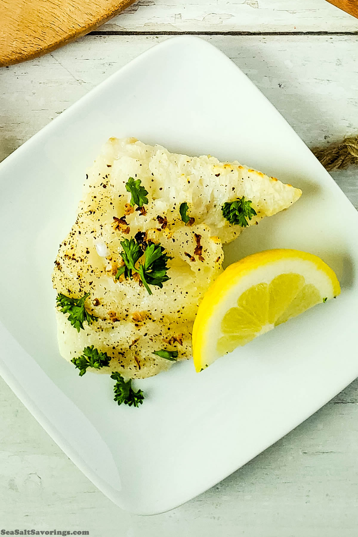 overhead view of plate of cod with wedge of lemon