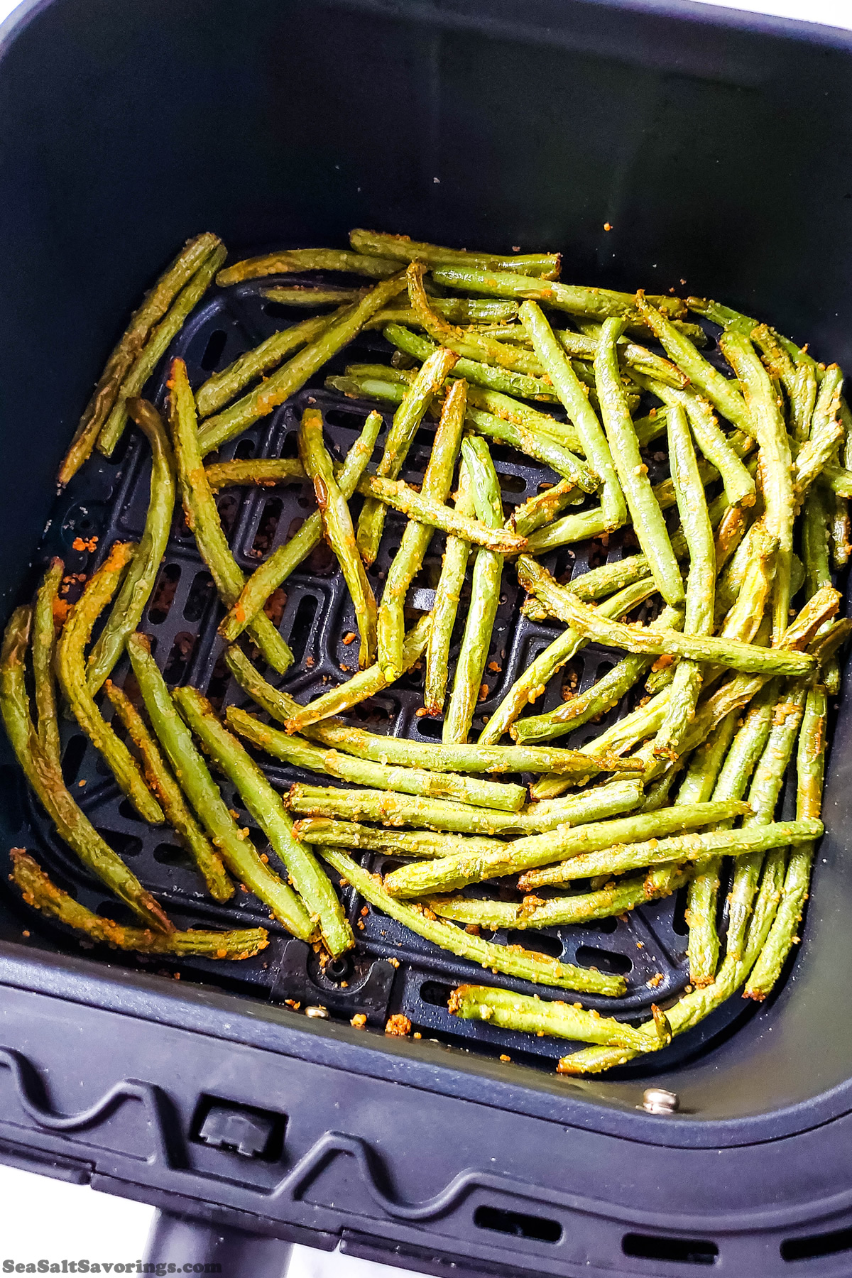 coated green beans freshly fried in an air fryer with golden crispy edges