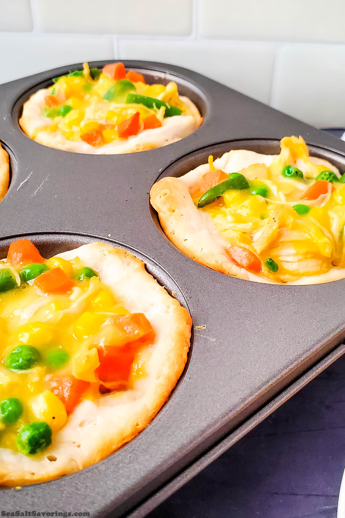 muffin baking dish with cooked chicken pot pies inside