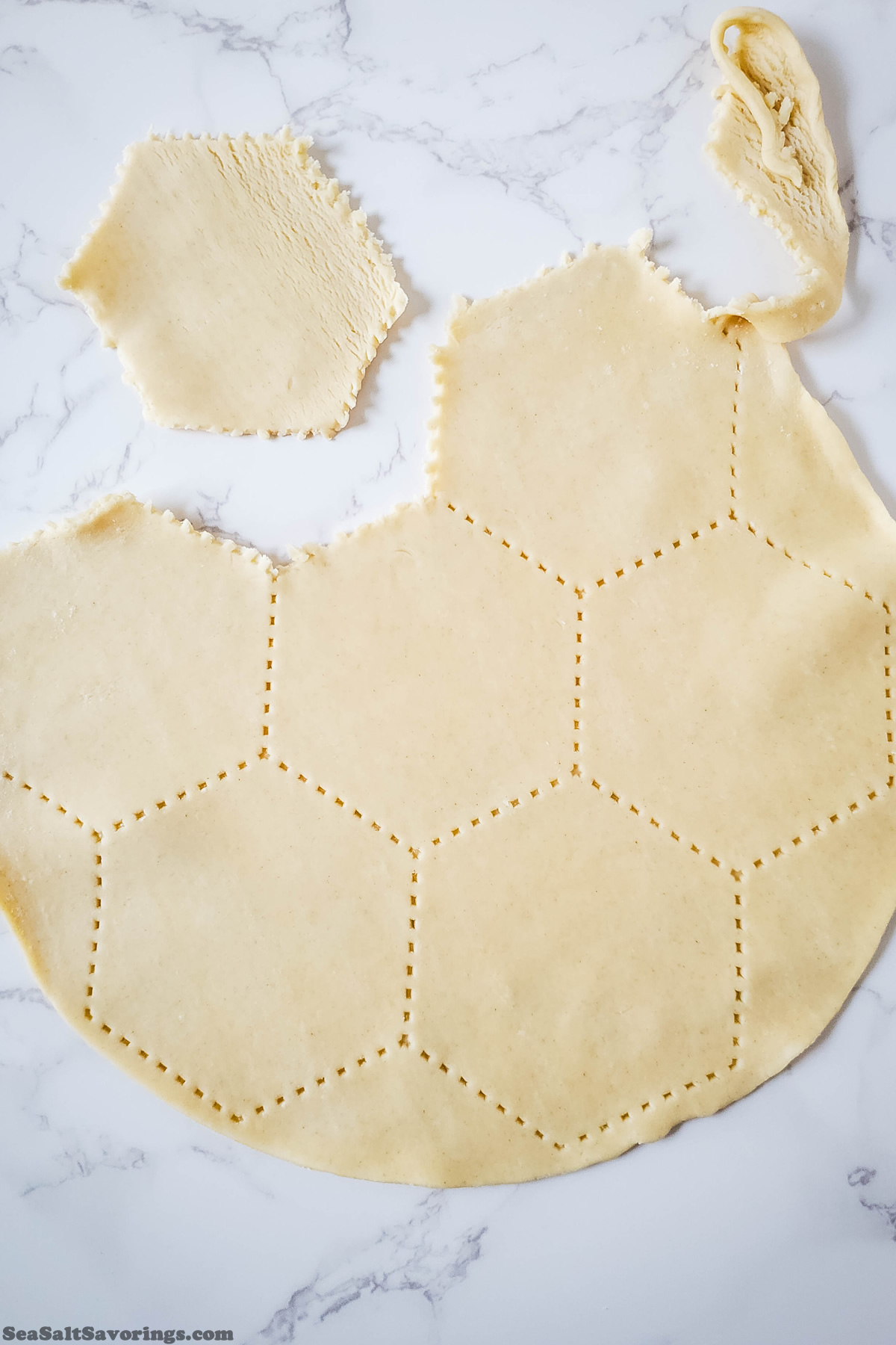 cutting a flattened sheet of pie crust dough into smaller shapes to fit into a cupcake tin