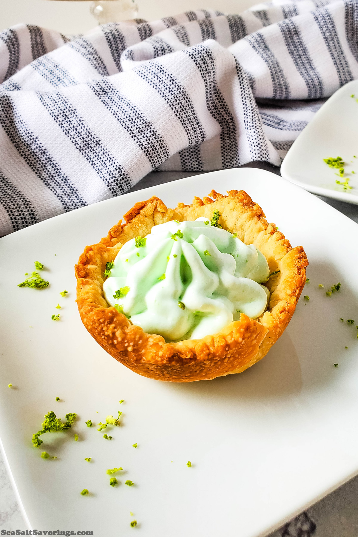 key lime pie bite on a plate with lime zest garnish