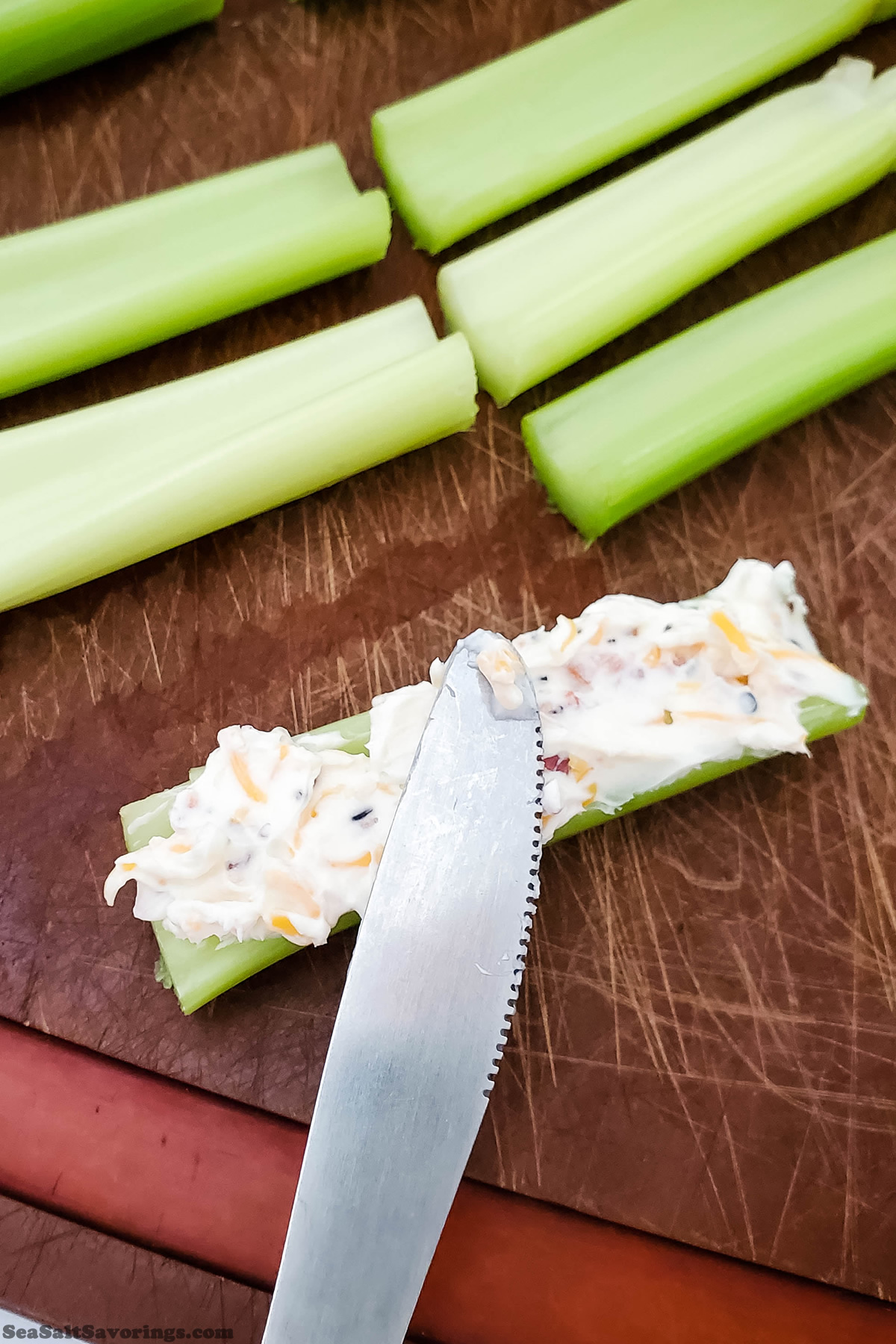 cut sticks of celery getting filled with cheese mixture